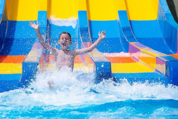 Child sliding down a water slide in a water park